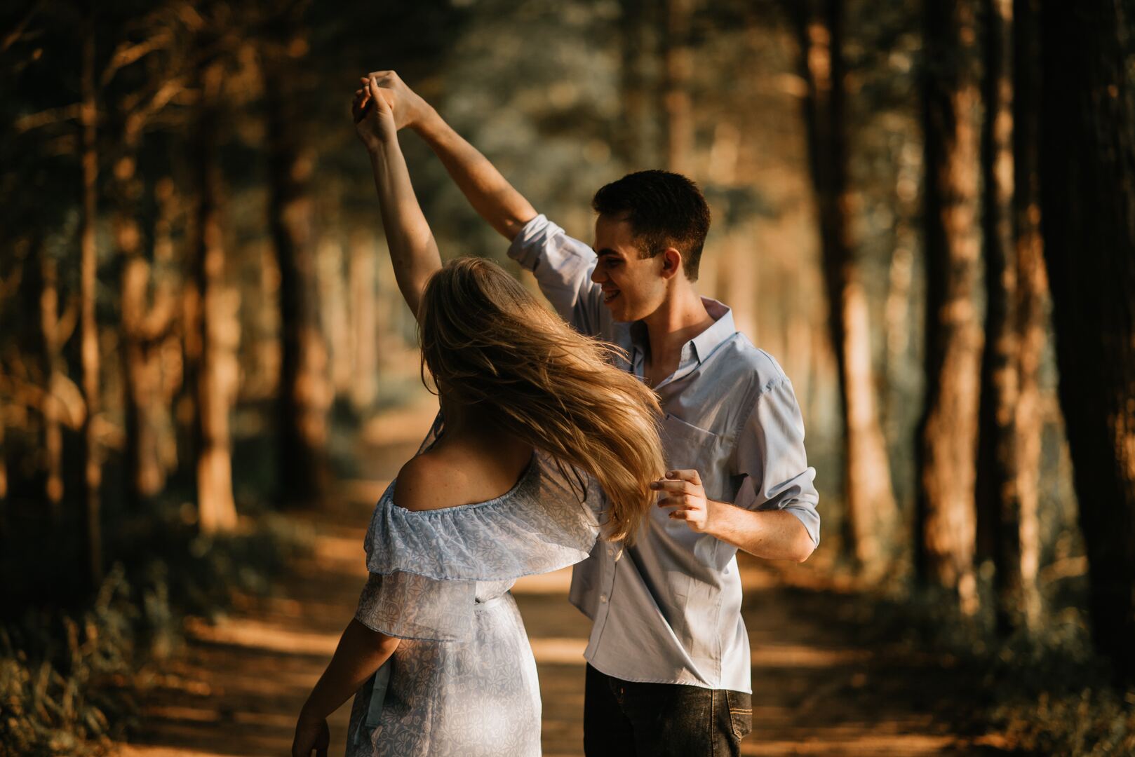 Frau und Mann tanzen beim Digital Detox im Wald