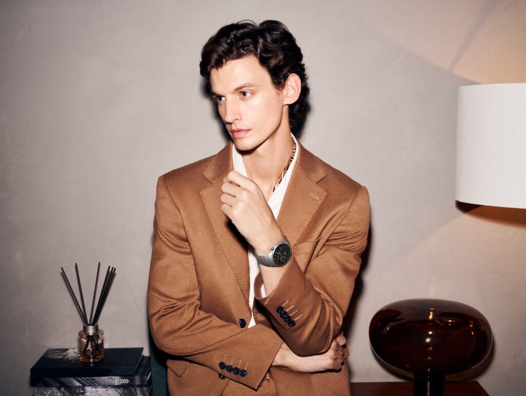 Ein Mann posiert in einem braunen Anzug mit der Huawei Smartwatch.
