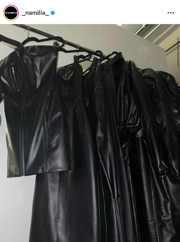 Schwarze Kleidungsstücke hängen auf einer Kleiderstange.