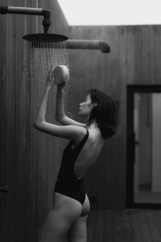 Schwarz-Weiß-Foto von Frau unter der Dusche