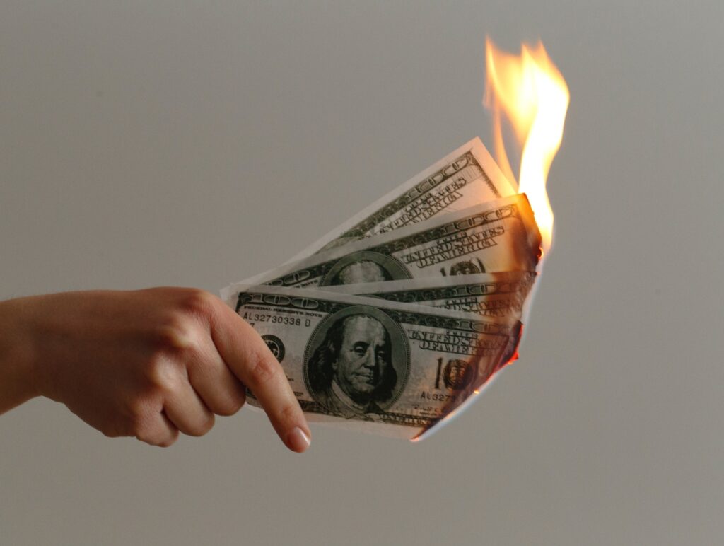 Geldscheine verbrennen in einer Hand