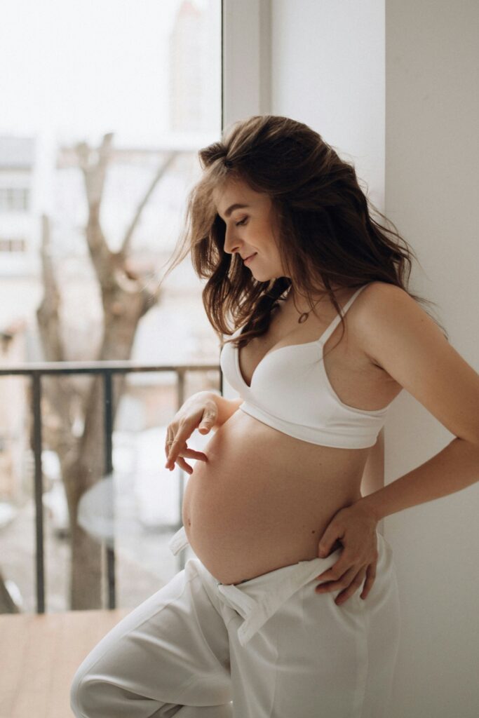 Eine schwangere Frau berührt ihren babybauch