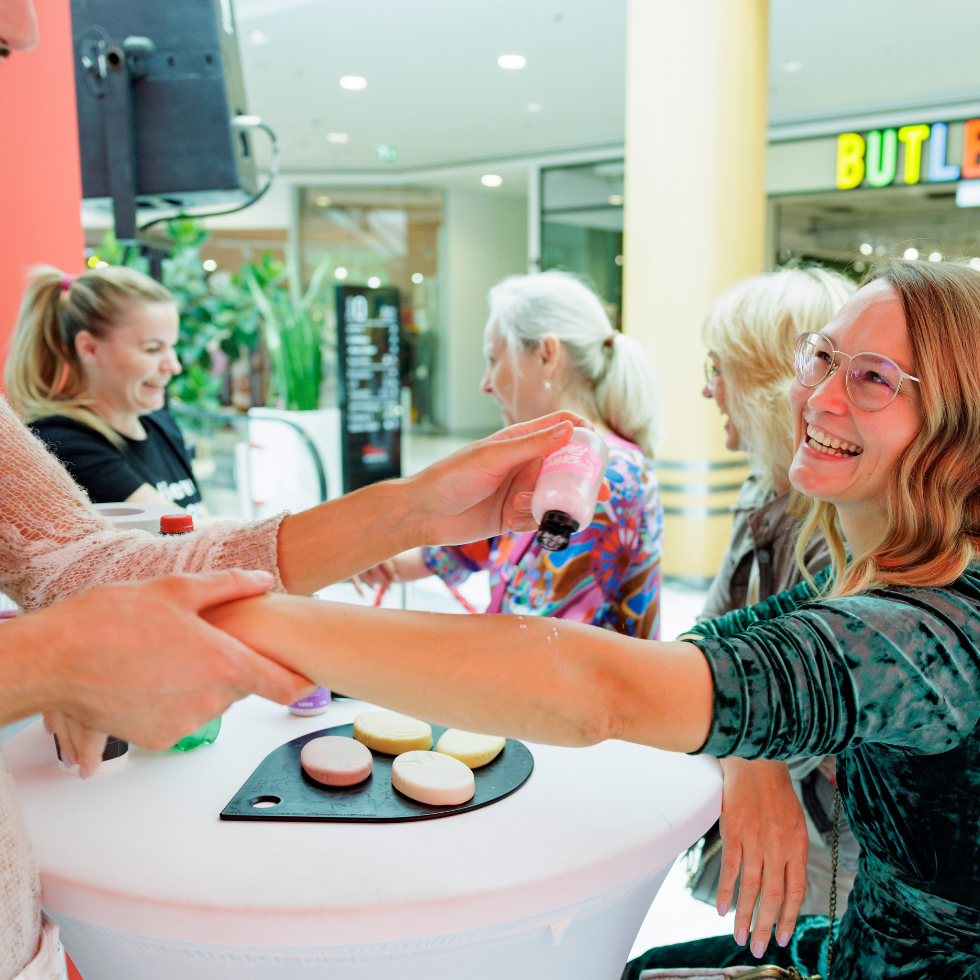 WSCS Fashion Circle mit der WIENERIN: Ein Lush-Mitarbeiter massiert die Hand und den Unterarm einer Besucherin