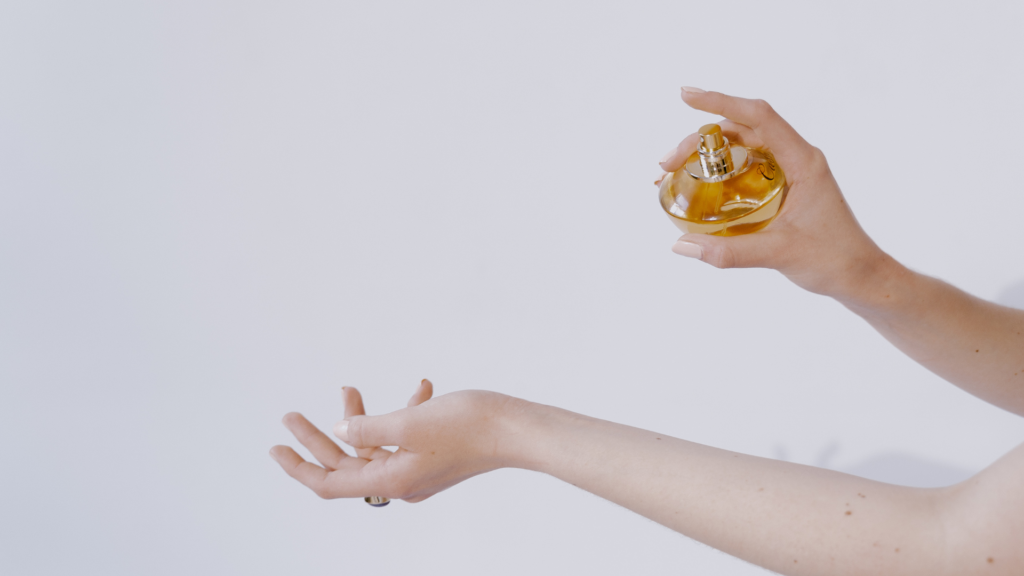 Parfumlayering, eine Dame sprüht sich Parfum auf die Hand