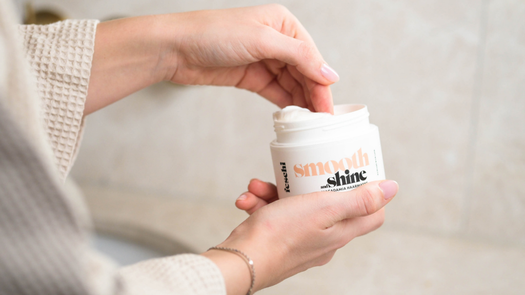 feschi Smooth & Shine Maske im Tiegel geöffnet, eine Hand greift hinein