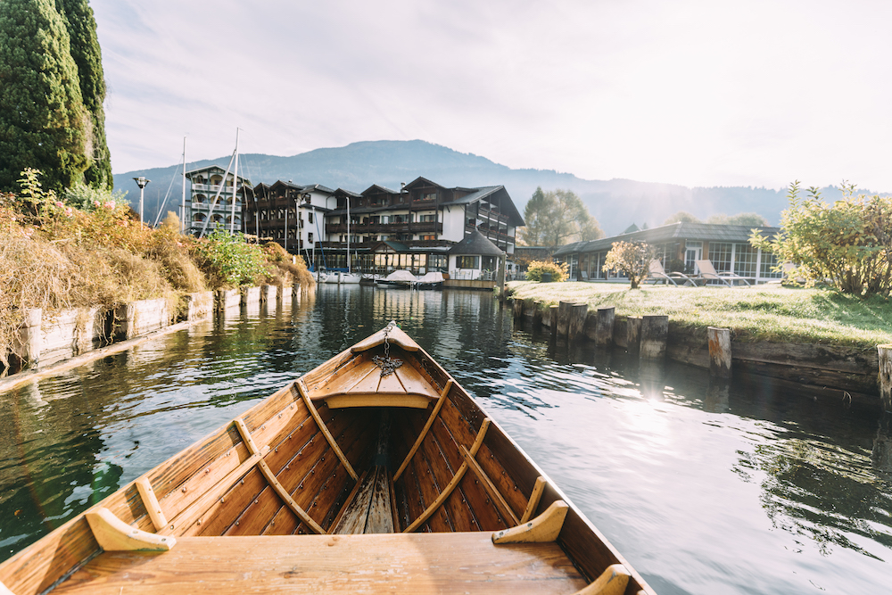 Von einem Holzboot aus sieht man auf ein Hotel