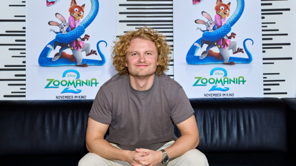 Dr. Bohl grinsend vor dem Zoomania 2 Plakat