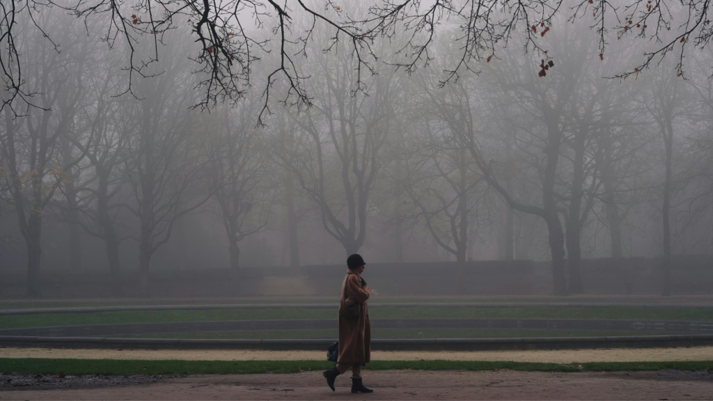 Eine Frau geht im Nebel
