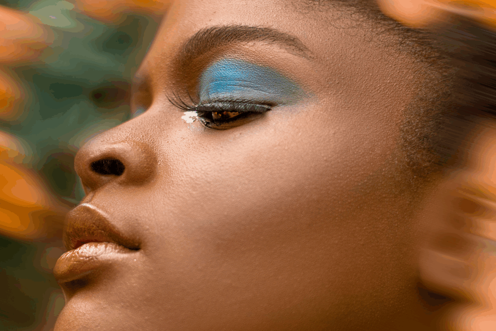 Beauty Trends 2026: Symbolfoto von Model, dunkle Haut, blauer Lidschatten, Make-up, beauty