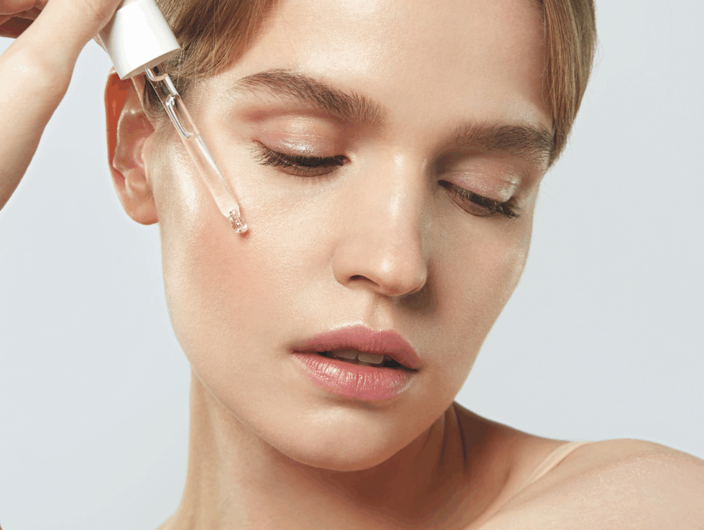 Porträt einer Frau, die sich ein Serum auf die Haut tropft