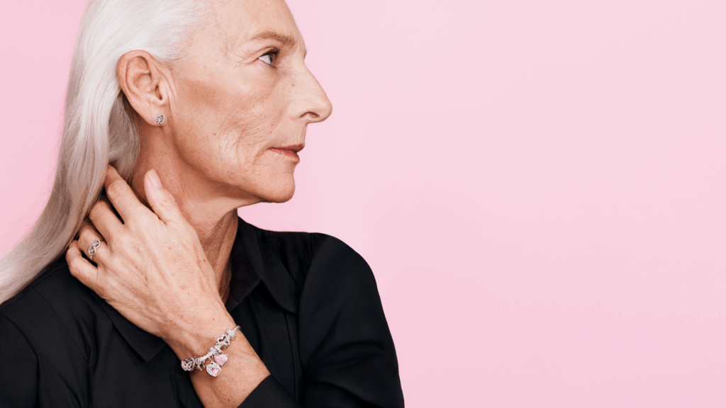 Eine Frau mit weißen Haaren trägt ein Armband von Pandora