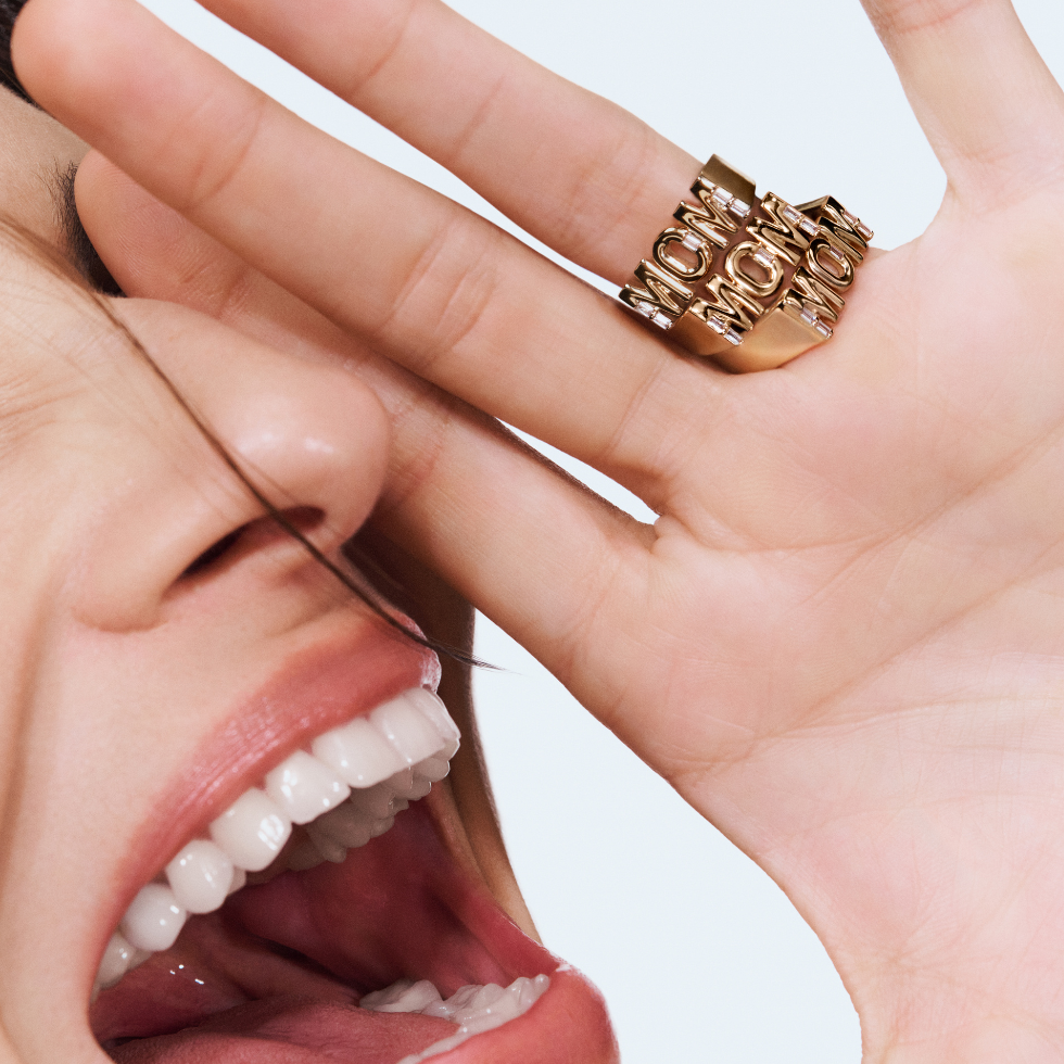 Eine Frau schreit lächelnd und trägt "Mom"-Ringe von Pandora