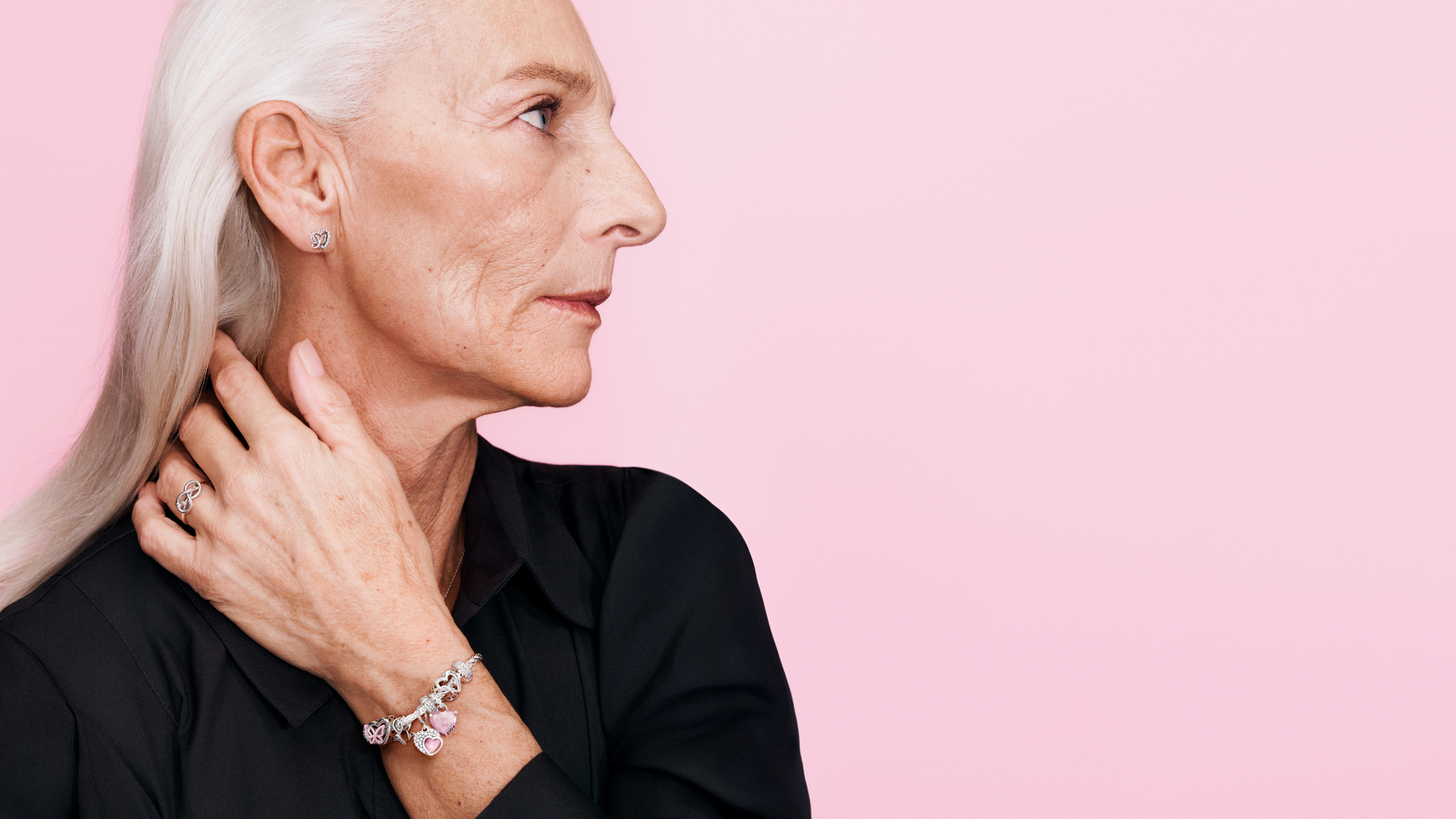 Eine Frau mit weißen Haaren trägt ein Armband von Pandora