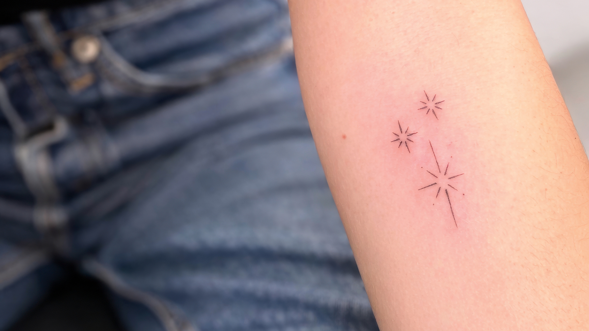 Tätowierte Sterne am Arm im Fineline-Stil