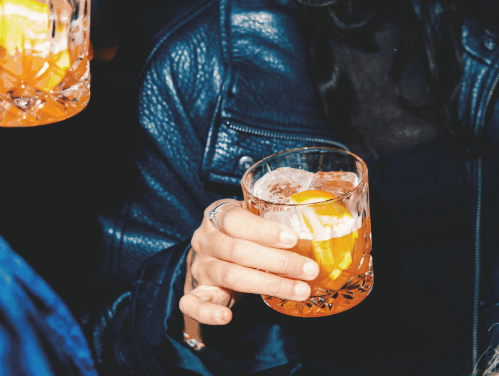 Nahaufnahme von einem orangenen Drink in der Hand