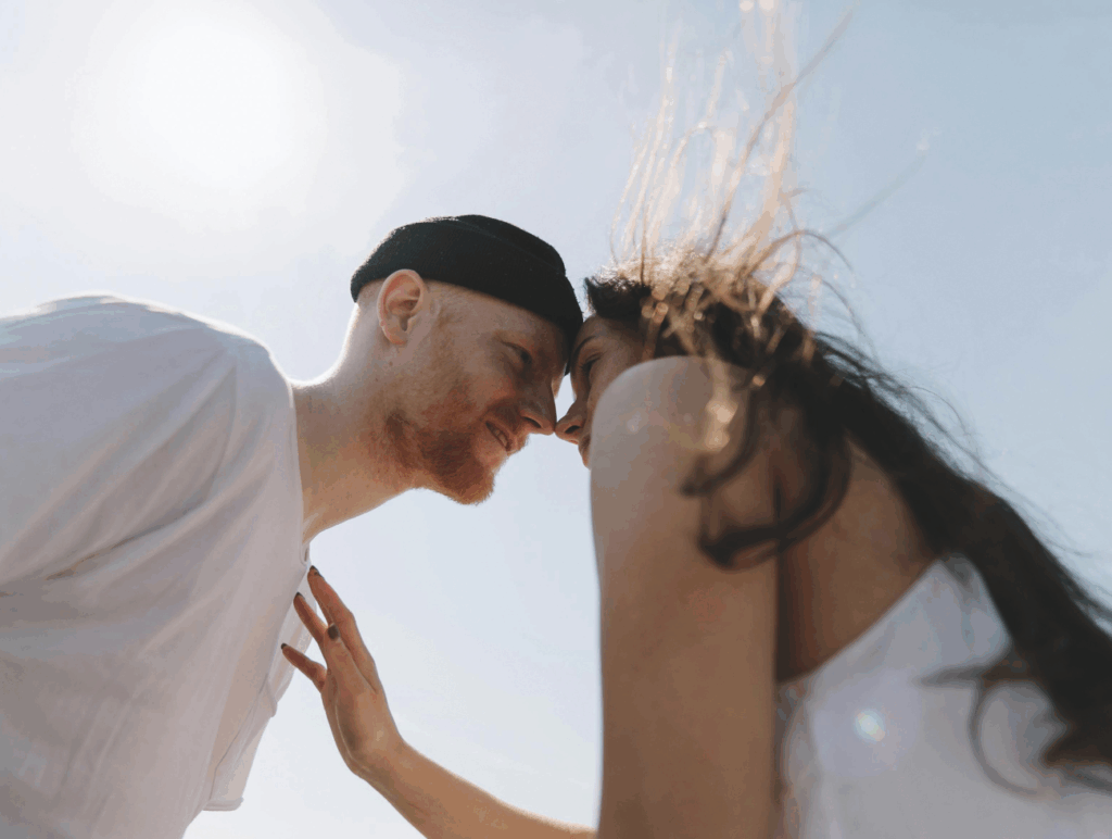 Ein Mann und eine Frau nah beieinander unter blauem Himmel