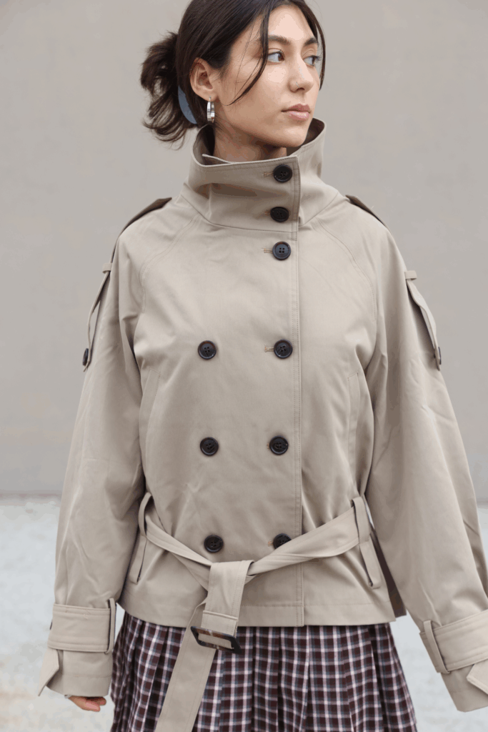 Eine Frau trägt einen High-Neck-Trenchcoat