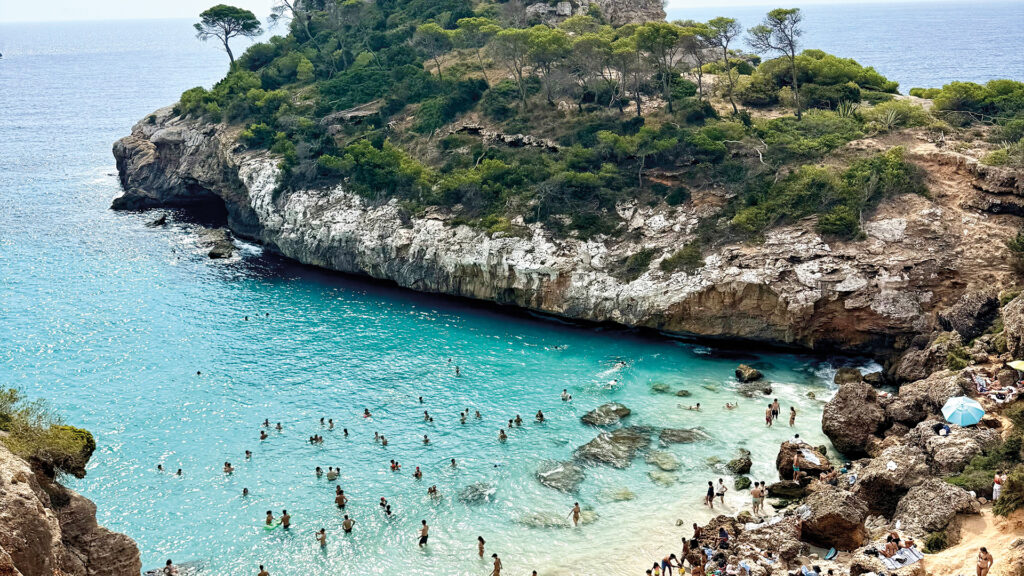 Türkisfarbene Badebucht auf Mallorca mit Felsküste und kristallklarem Meer.