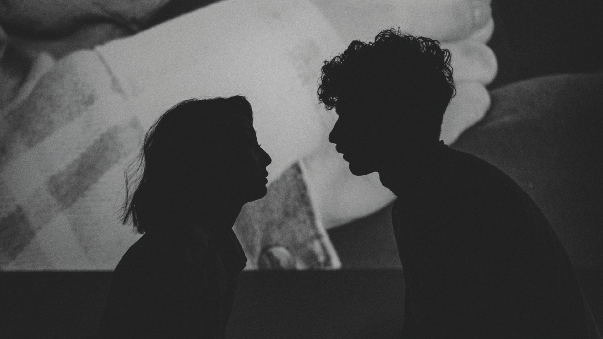 Silhouette von einer Frau und einem Mann, die sich ansehen mit Projektion im Hintergrund